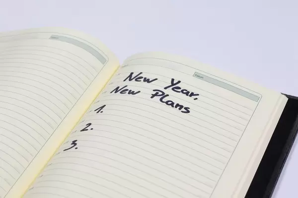 Neues Jahr, Neue Pläne - Neujahrvorsätze auf einem Notizbuch