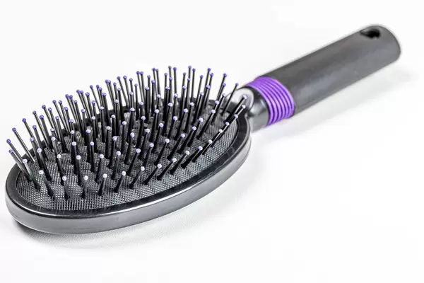 New black hairbrush on a white background