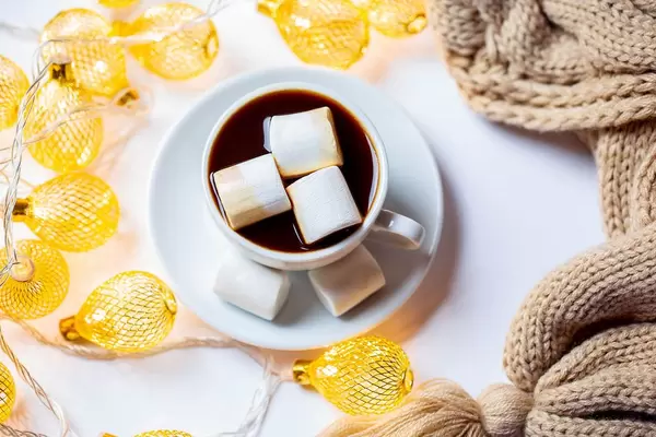 New year background with a Cup of coffee with marshmallows and garland