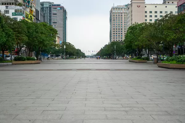 Nguyen Hue Walking Street in the Daytime with few People and Flag Poles on the other End