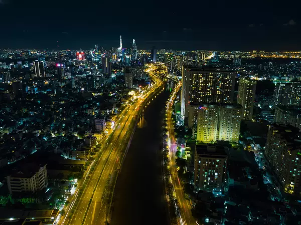 Night Drone Photo of Saigon River between District 1 and District 4 and the Skyline with Bitexco Financial Tower and Lanmark 81 in Ho Chi Minh City, Vietnam
