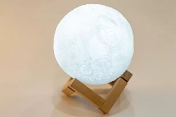 Night light in the form of a shining moon on a wooden stand (Flip 2019)