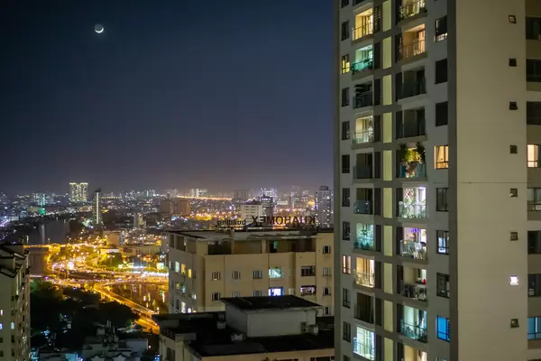 Night Photo of Traffic in Saigon, Saigon River and District 5 with Bright Moon in Ho Chi Minh City, Vietnam