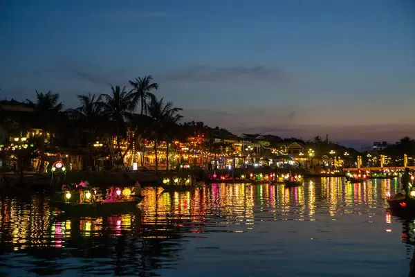 Night Photo of Wooden Rowing Boats with Light Reflection of Lanterns in the Water on a River in the Old Town in Hoi An, Vietnam