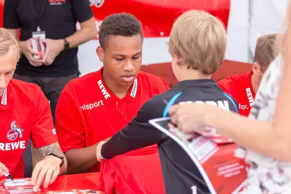 Nikolas Nartey signiert das Trikot eines jungen Fans