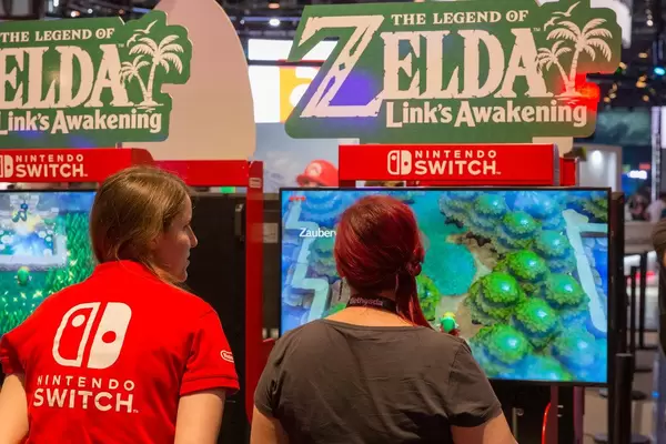Nintendo Switch Team auf der Gamescom in Köln, mit einer Spielemessebesucherin vor dem neuen Zelda-Videospiel "Link's Awakening"