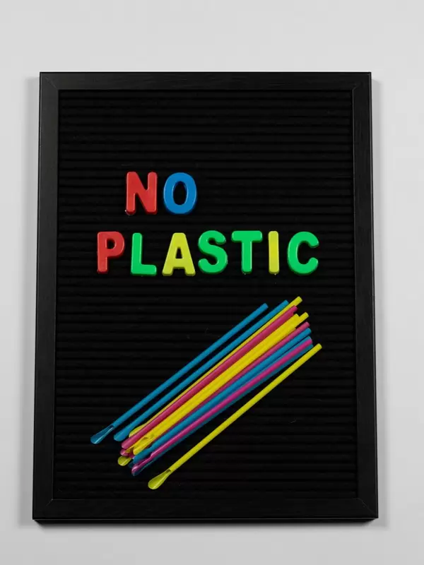 No Plastic in bunten Buchstaben mit Trinkhalmen auf schwarzer Pinnwand