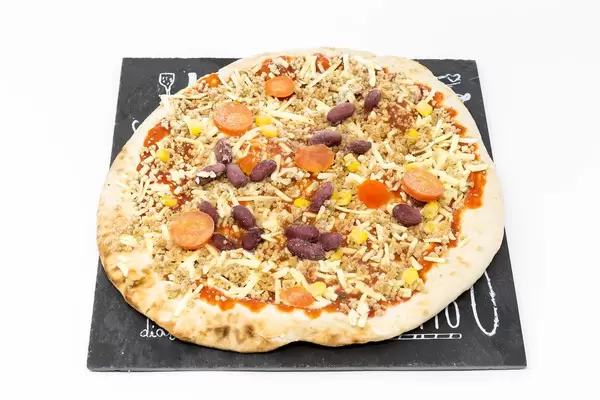 Noch nicht gebackene Tiefkühlpizza mit Bohnen, Tomaten und Mais aus schwarzer Pizzaplatte