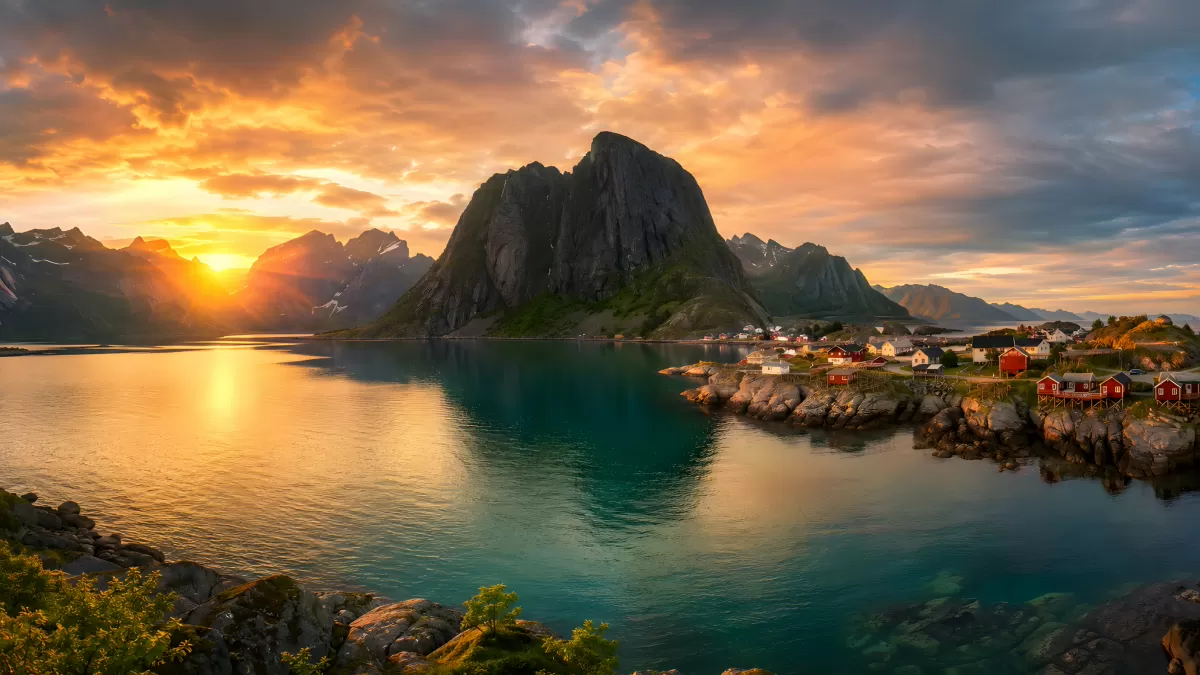 Norwegisches Fischerdorf bei Sonnenuntergang am Fjord