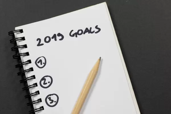 Notebook with 2019 goals on black desk
