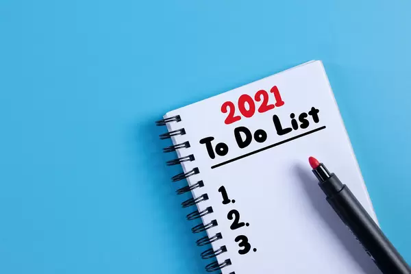 Notebook with 2021 to do list on blue background
