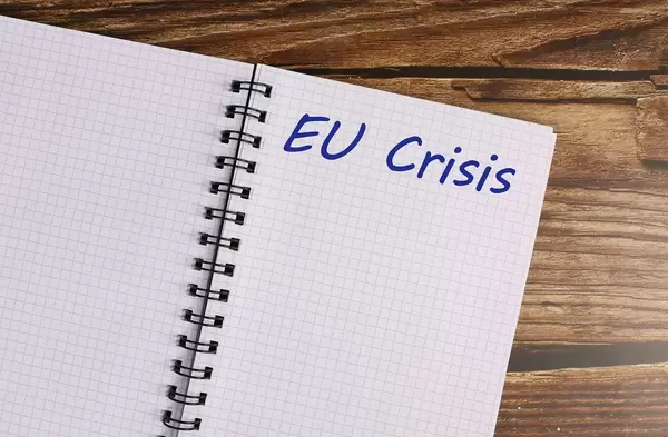 Notebook with EU Crisis text on a wooden table