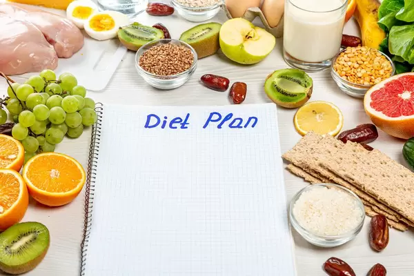 Notebook with the inscription "diet plan" and ingredients around