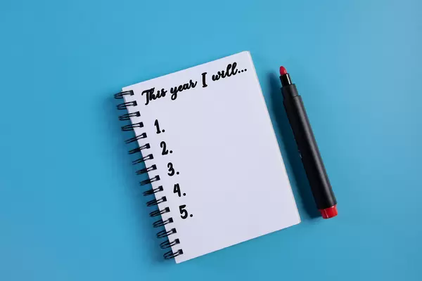 Notebook with This year I will text on blue background