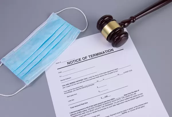 Notice of Termination form with medical face mask and judge gavel