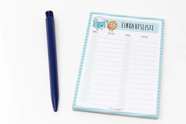 Notizblock für die Einkaufsliste mit Kugelschreiber vor weißem Hintergrund
