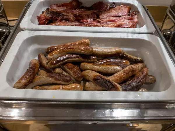 Nürnberger Röstbratwürstchen in Warmhaltebehältern bei einem Buffet eines Hotels