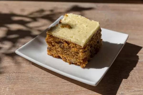Nut cake with white chocolate topping on square plate