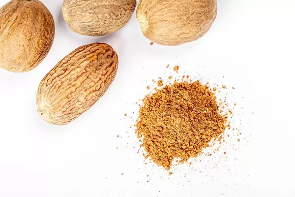 Nutmeg and ground nutmeg on white background, top view (Flip 2020)