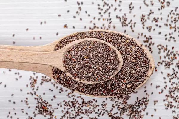Nutritious chia seeds on a wooden spoons. Top view (Flip 2019)