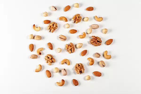 Nuts of different types laid out in the shape of a circle on a white background, top view (Flip 2020)