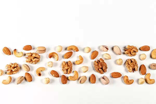 Nuts of different types on a white background with free space, top view (Flip 2020)
