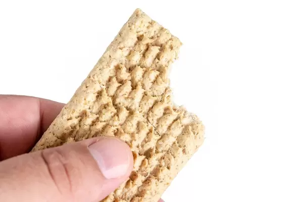 Oat Crackers in the hand above white background