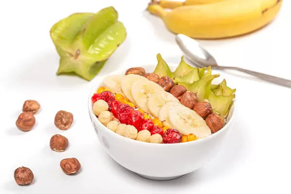 Oatmeal breakfast with fruits, hazelnuts and dried cherries