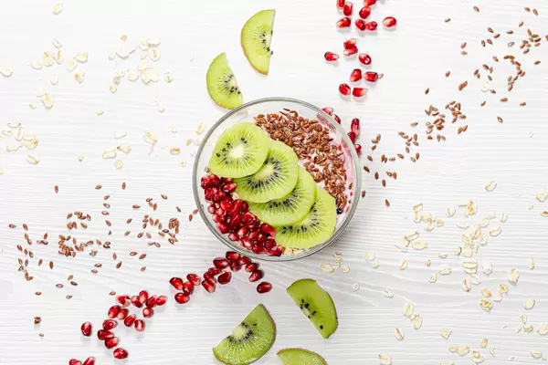 Oatmeal porridge with flax seeds, kiwi pieces and pomegranate. Top view (Flip 2019)