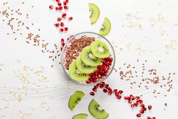Oatmeal porridge with flax seeds, kiwi pieces and pomegranate. Top view