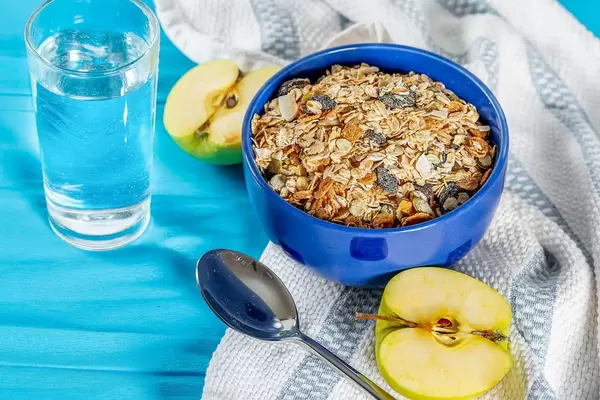 Oatmeal porridge with nuts and dried fruits and a glass of water-Breakfast during the diet