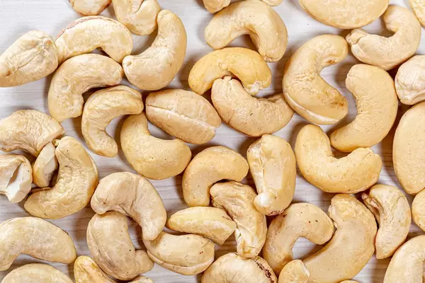 Obere Aufnahme von rohen Cashewnüssen auf einem Holztisch