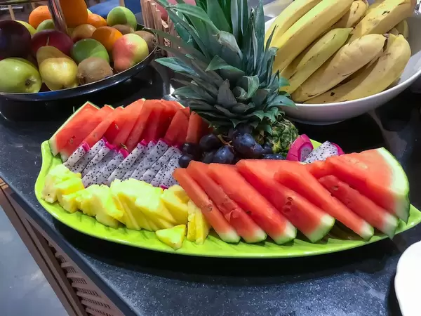 Obstteller mit Wassermelone, Ananas, Drachenfrucht und Trauben