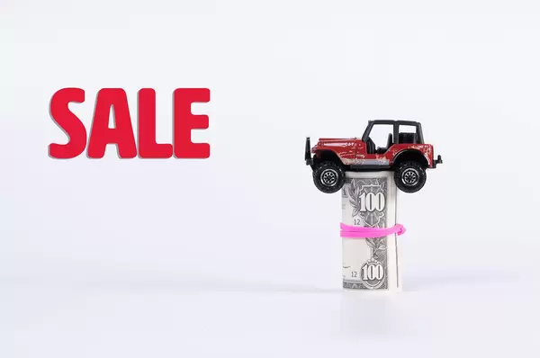 Off-road car with money roll and Sale text on white background