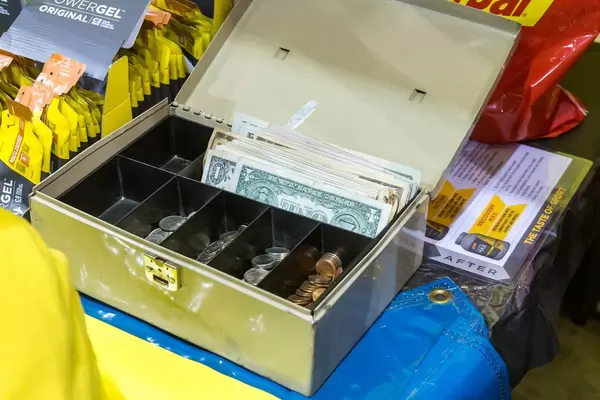 Offene Geldkassette mit amerikanischem Kleingeld und US-Dollarnoten