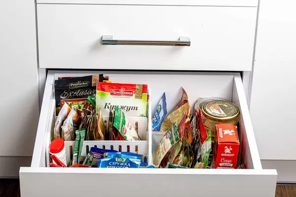 Offene Küchenschublade mit verschiedenen Gewürzen und Kräutern