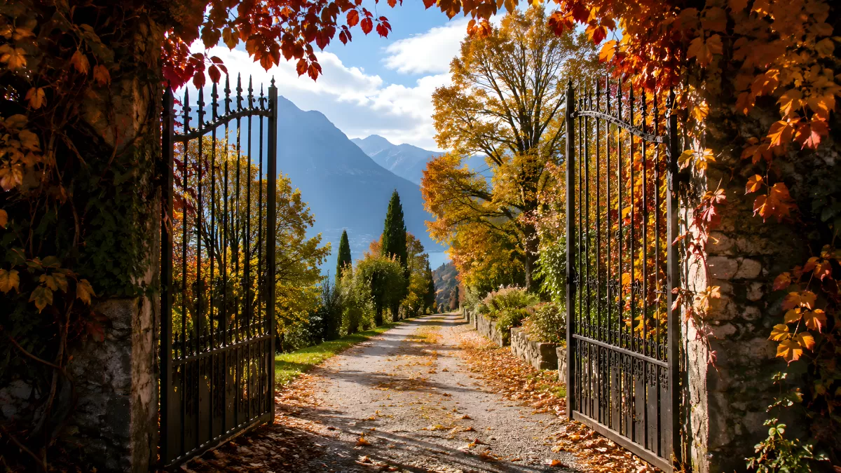 Offenes Eisentor führt in herbstlichen Gartenweg