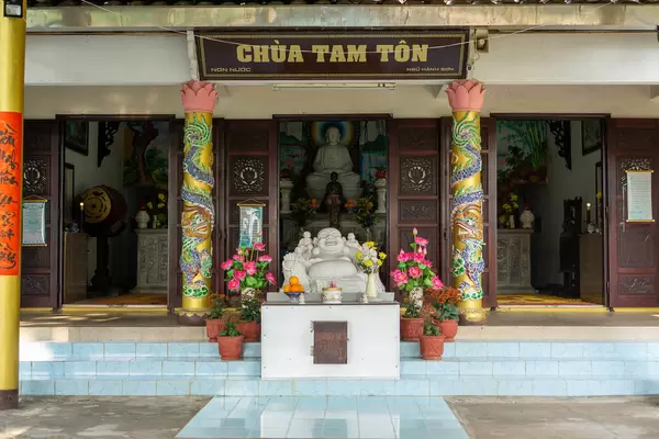 Offerings and Decorations around many different Buddha Statues in front and inside Tam Ton Pagoda at Marble Mountains in Danang, Vietnam