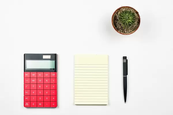 Office desk table layout with calculator, notepad and cactus
