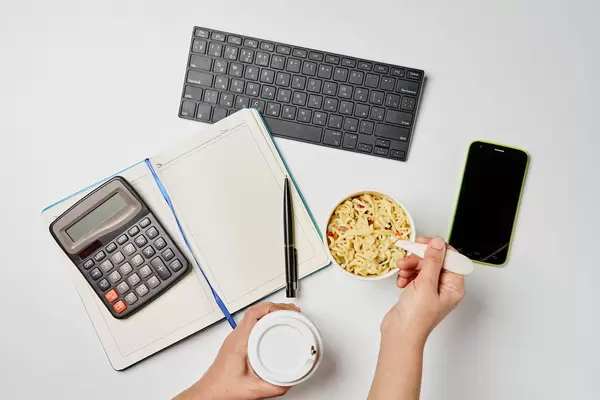 Office worker eating instant noodle while working