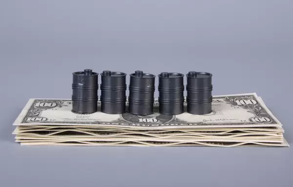Oil barrels on a stack of money