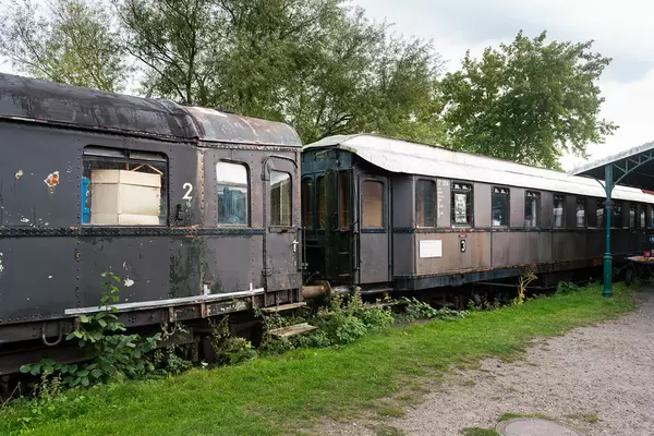 Old abandoned German train cars covered in rust and grass