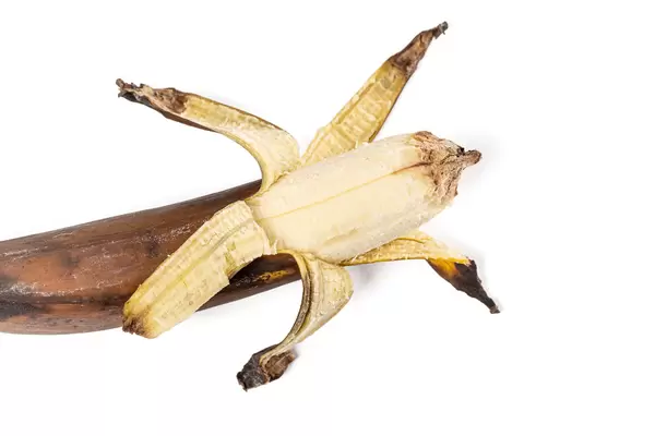 Old dark brown banana on background