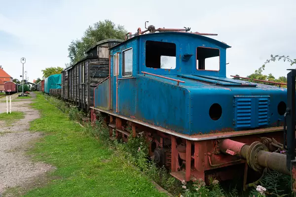 Old German abandoned locomotive in front of the wooden wagon train