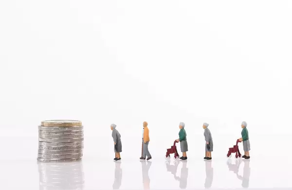 Old people walking to the stack of coins on white background