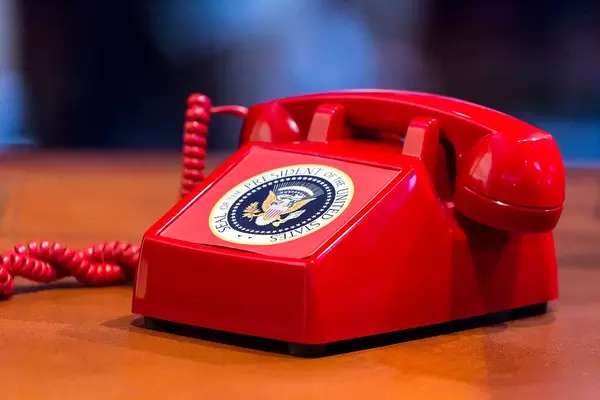 Old red vintage phone with Seal of the president of the united states as a sticker on it