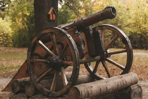 Old wooden cannon on a pedestal in the autumn park