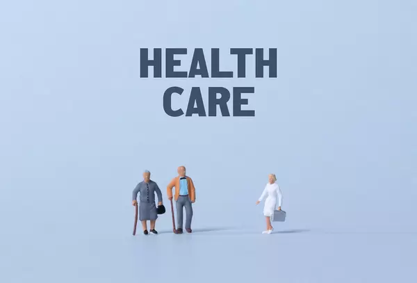 Older couple and doctor with Health care text