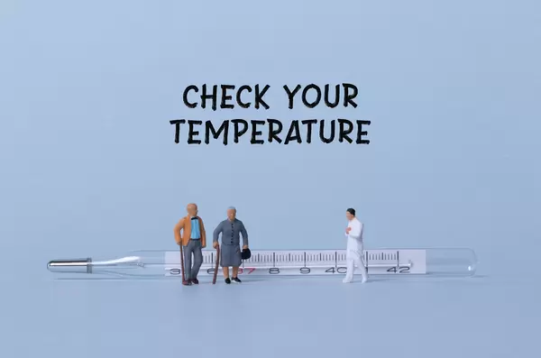 Older couple and doctor with thermometer and Check your temperature text