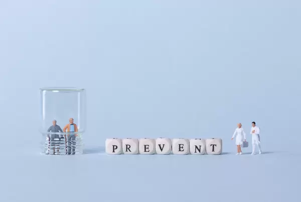 Older couple inside glass, two doctors and Prevent text